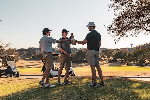 three golfers sharing a drink