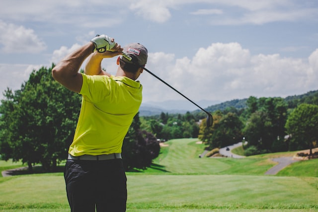 golfer in green shirt finishing swing driver