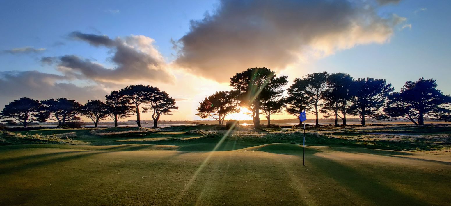 sunset behind golf hole